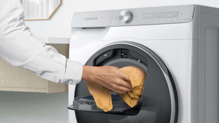 Đồ giặt bổ sung được thêm vào cửa Add Wash đang mở bằng tay.